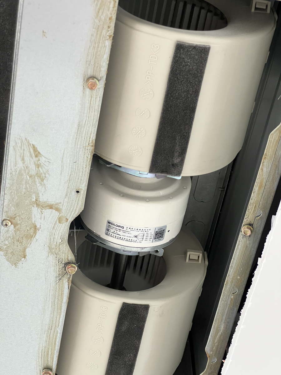 設(shè)備內(nèi)部兩只并排的離心風機特寫，風機外殼印有品牌與型號標識，安裝在鍍鋅金屬風道框架上